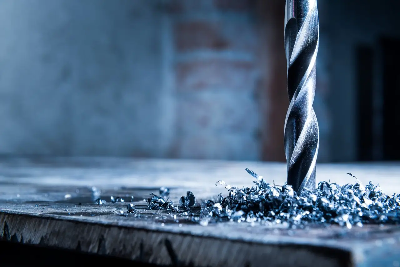 Bohrer mit Spänen auf einer Metallplatte